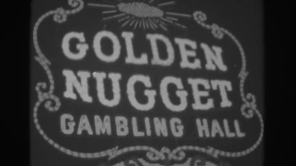 Black-and-white 1962 Las Vegas frame with the Golden Nugget Gambling Hall sign centered, including bright lettering, scrollwork, and a small sunburst motif.