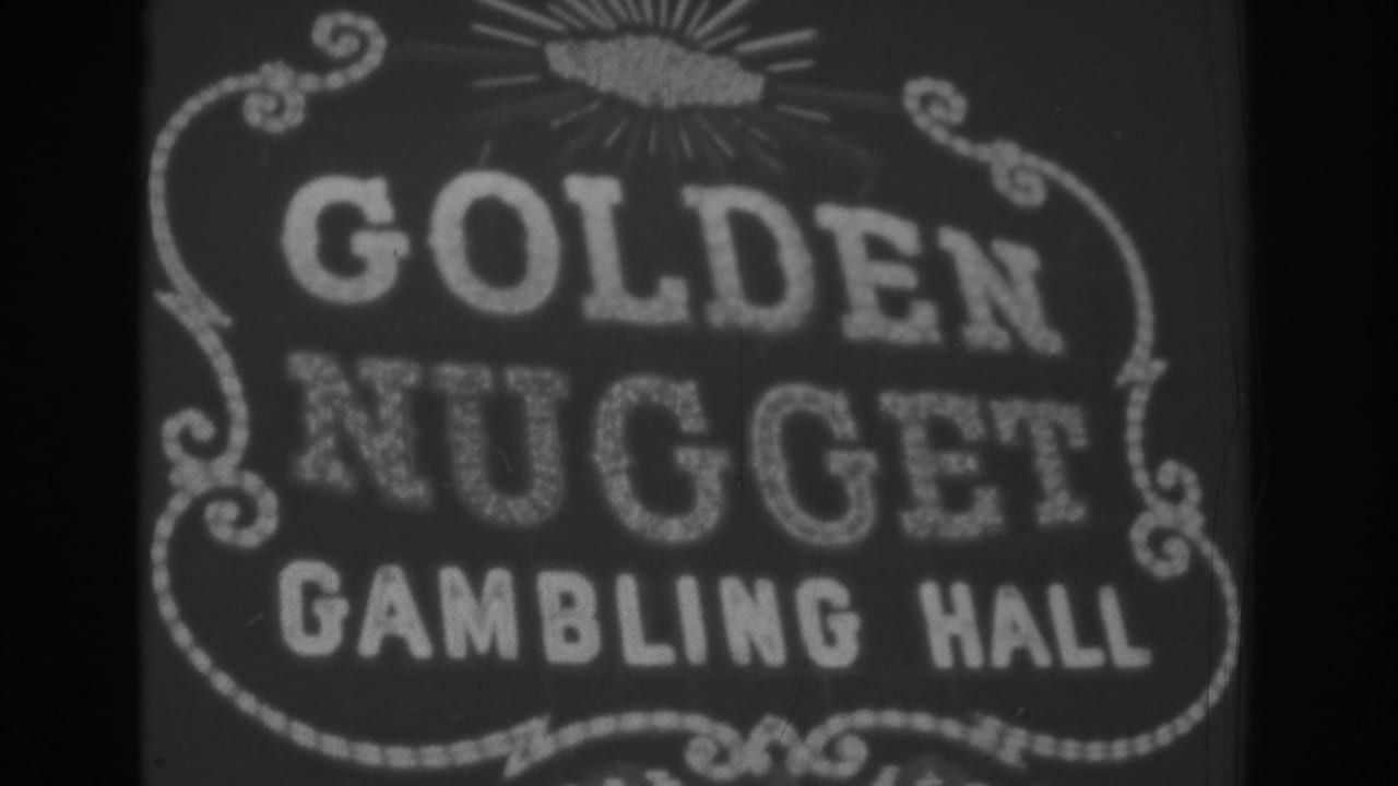 Black-and-white 1962 Las Vegas home-movie frame showing a close, slightly soft view of the illuminated Golden Nugget Gambling Hall sign.