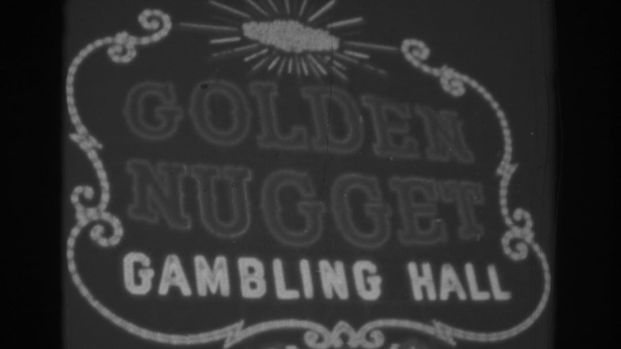 Black-and-white 1962 Las Vegas frame where the Golden Nugget lettering is dimmer while the Gambling Hall text and sign border remain visible.