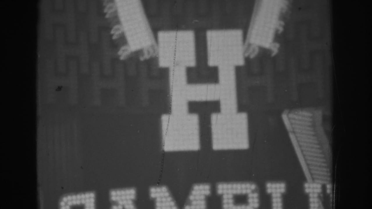 1962 Las Vegas 8mm frame showing the Golden Nugget sign above a large lit H and surrounding patterned lights.