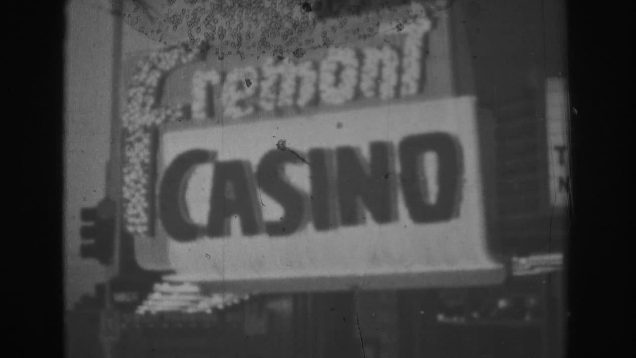 1962 Las Vegas home-movie frame showing the illuminated Fremont Casino marquee in soft black-and-white focus.