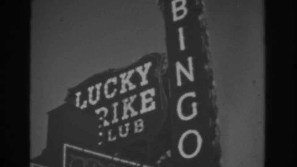 1962 Las Vegas 8mm frame with the Lucky Rike Club sign partly overlapped by a vertical BINGO sign.