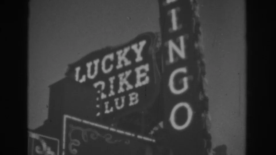 1962 Las Vegas 8mm frame showing a closer, soft-focus view of the Lucky Rike Club and BINGO signs.