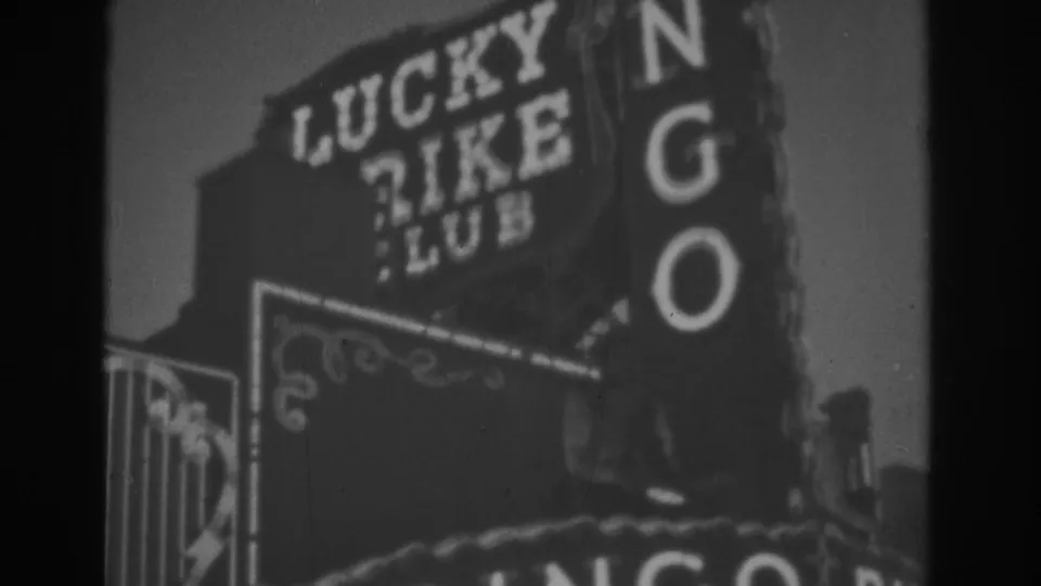 1962 Las Vegas 8mm frame showing Lucky Rike Club signage, the vertical BINGO sign, and partial lower decorative sign elements.