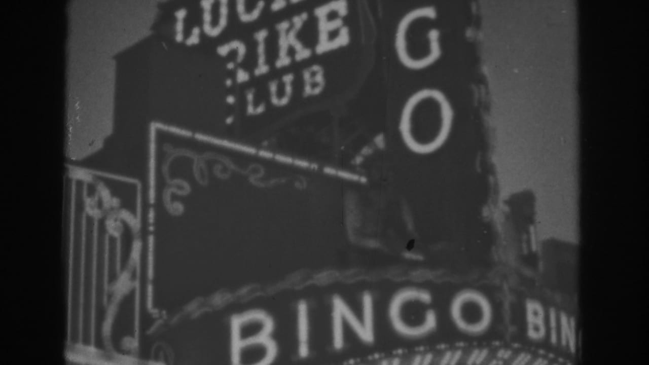 1962 Las Vegas 8mm frame showing BINGO lettering, Lucky Strike Club marquee, and decorative neon trim in soft black-and-white focus.