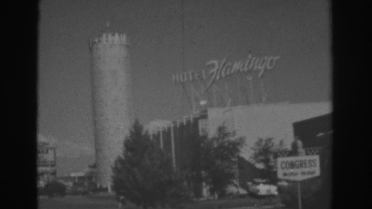 1962 Las Vegas home-movie frame showing the Hotel Flamingo tower and script sign with a Congress Motor Hotel sign near the street.