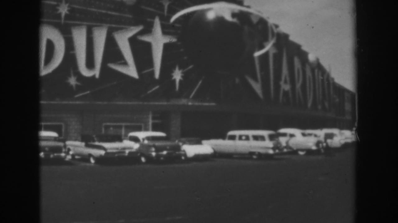 Stardust exterior with marquee lettering and parked classic cars along the front.