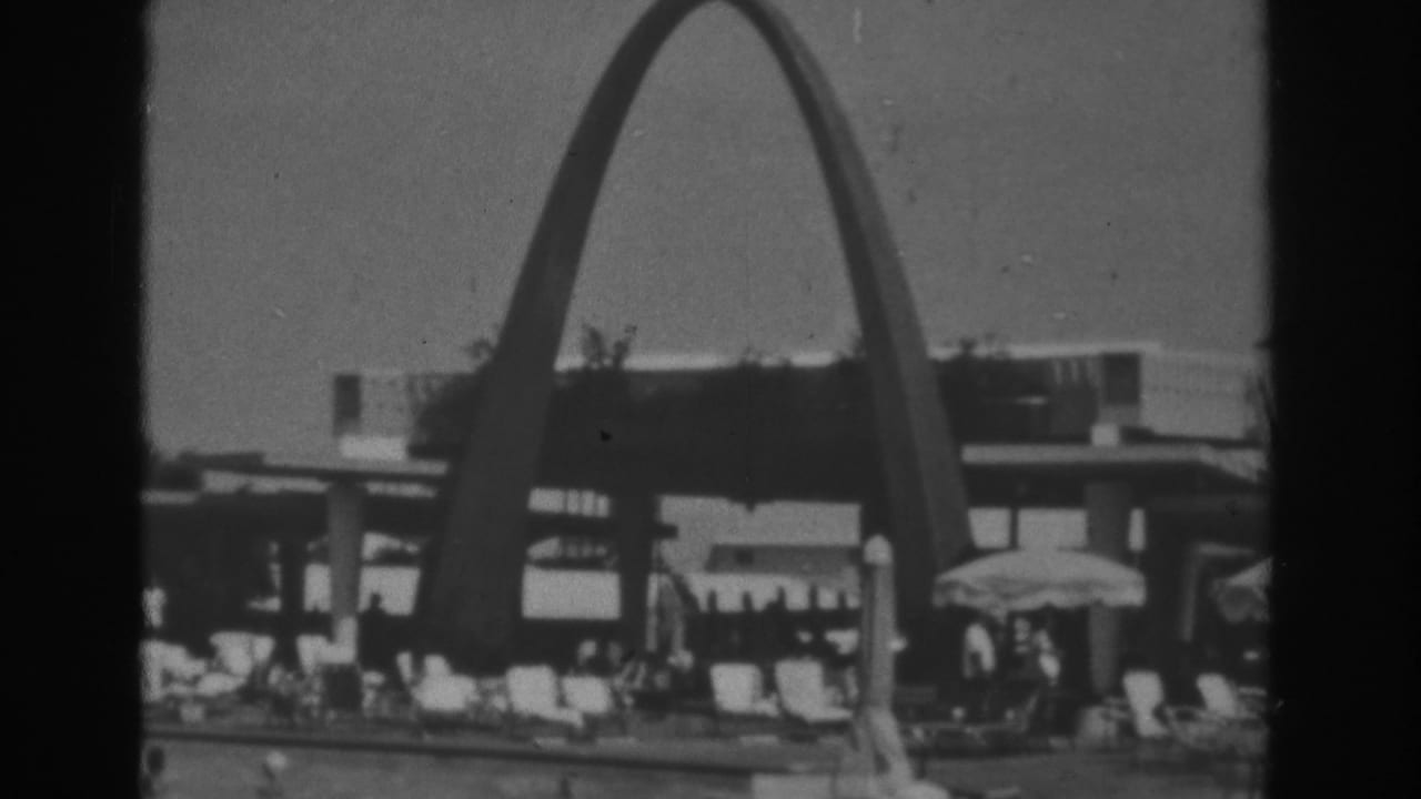 1962 Las Vegas poolside resort view with the large arch, seated visitors, umbrellas, lounge chairs, and the adjacent building facade.