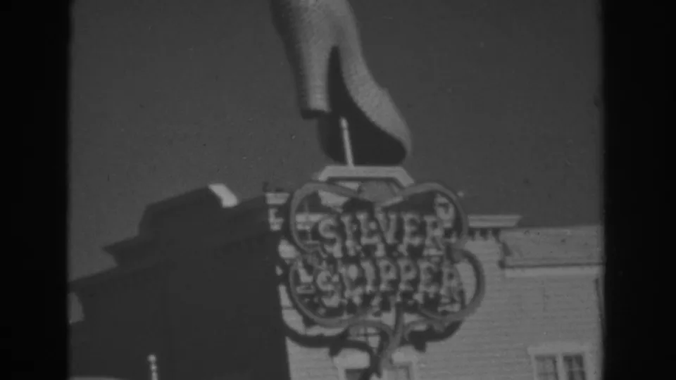 1962 Las Vegas 8mm frame showing the Silver Slipper sign with an oversized high-heeled shoe above a building facade.