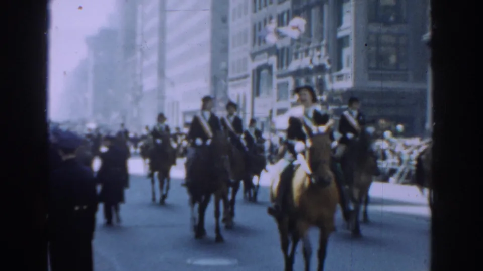 The parade continues with mounted riders on brown horses moving through New York City in bright 1962 home-movie footage.