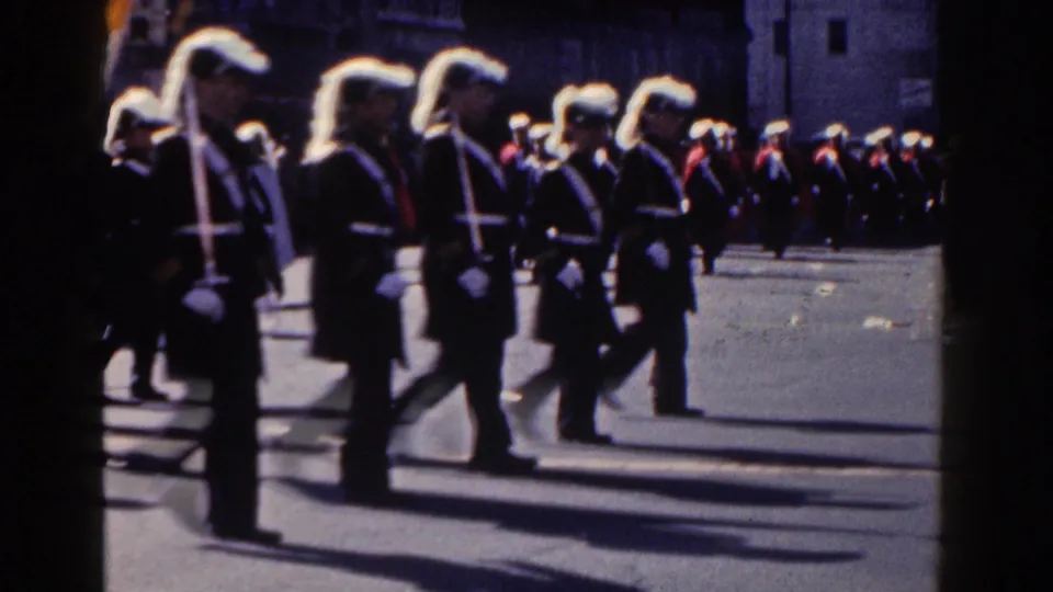 Close 1962 New York City home-movie view of plumed uniformed marchers moving through the parade route.