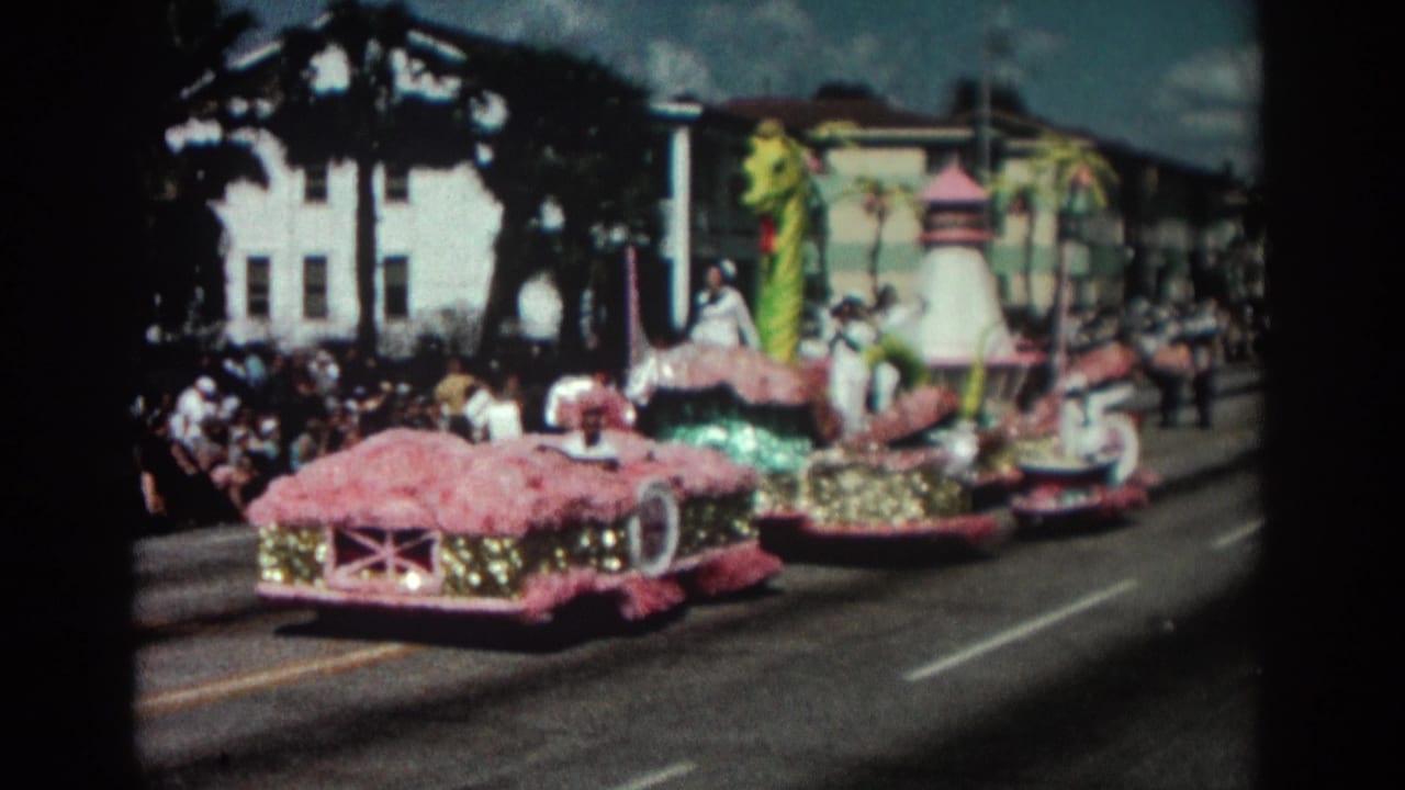 1962 Pasadena parade footage showing a pink and gold float with a green sea monster element moving past sidewalk spectators.