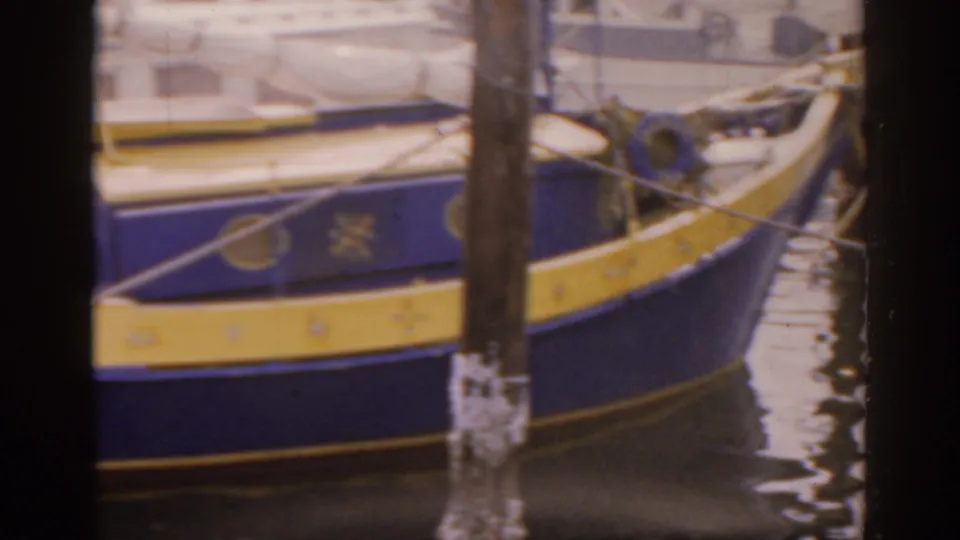 The final frame shows the forward side of the blue and yellow boat at the pier, with a life preserver, mooring lines, and rippled water nearby.