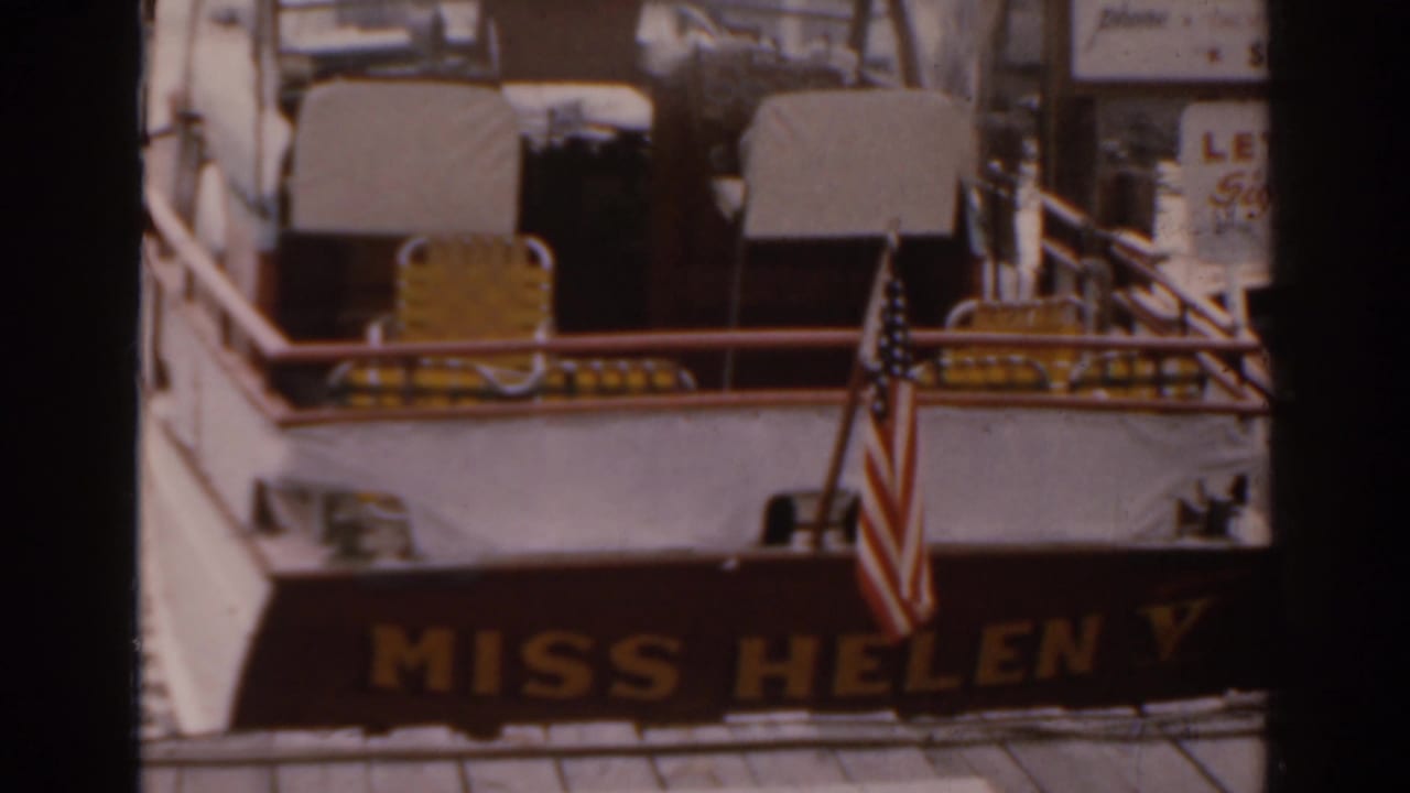 Stern of the Miss Helen V riverboat with an American flag and yellow deck chairs.