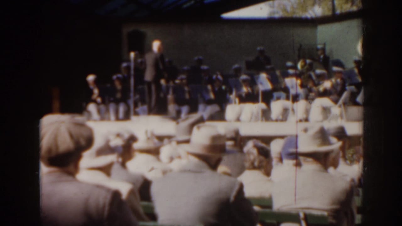 Spectators seen from behind face a raised outdoor orchestra stage in Florida, consistent with the 1963 clip metadata.