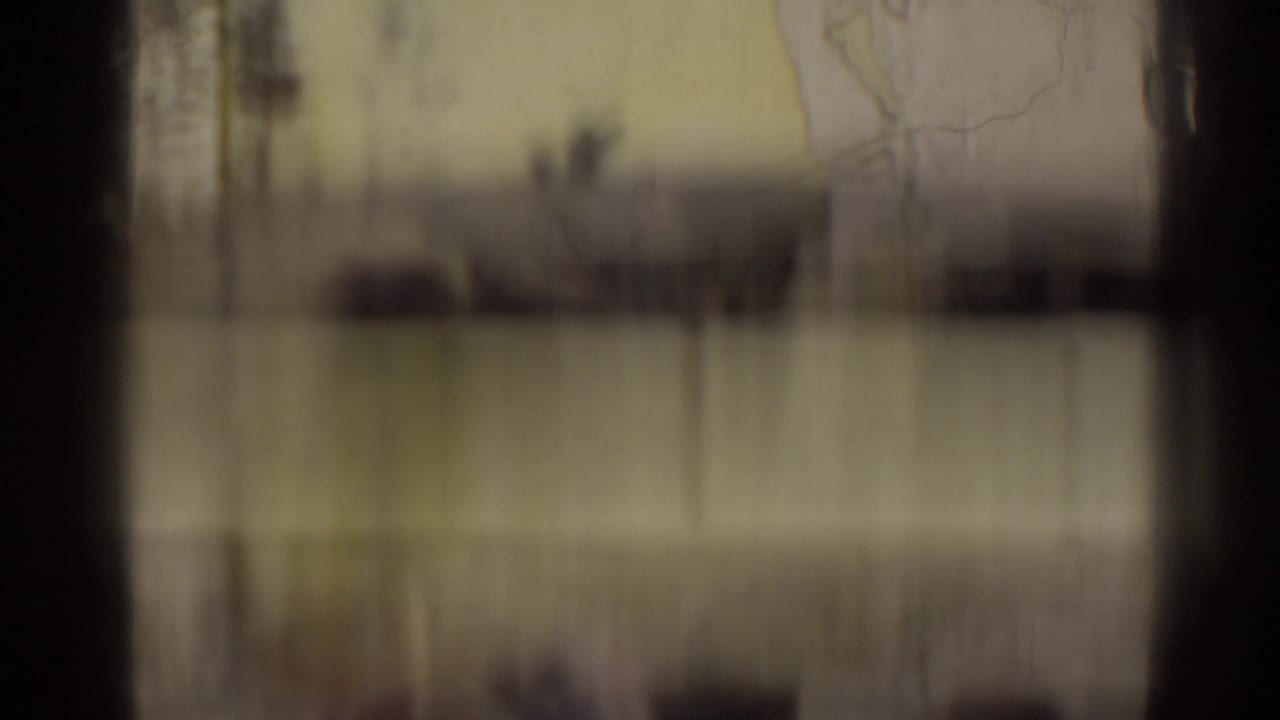 Blurred film frame with vertical bands and little readable subject detail.