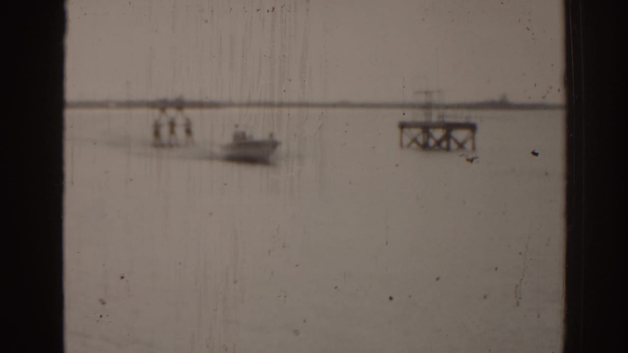 Distant boat on open water with a small dock or platform at right.