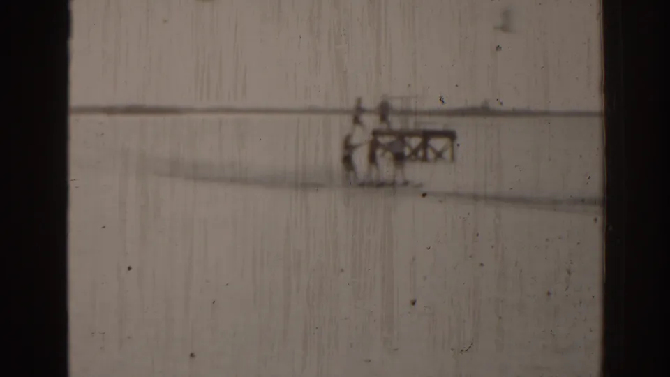 Soft 8mm frame showing distant water skiers beside a small platform or dock on Florida water.