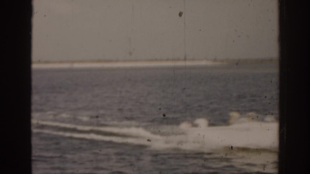 Motorboat on open water with a broad white wake trailing behind.