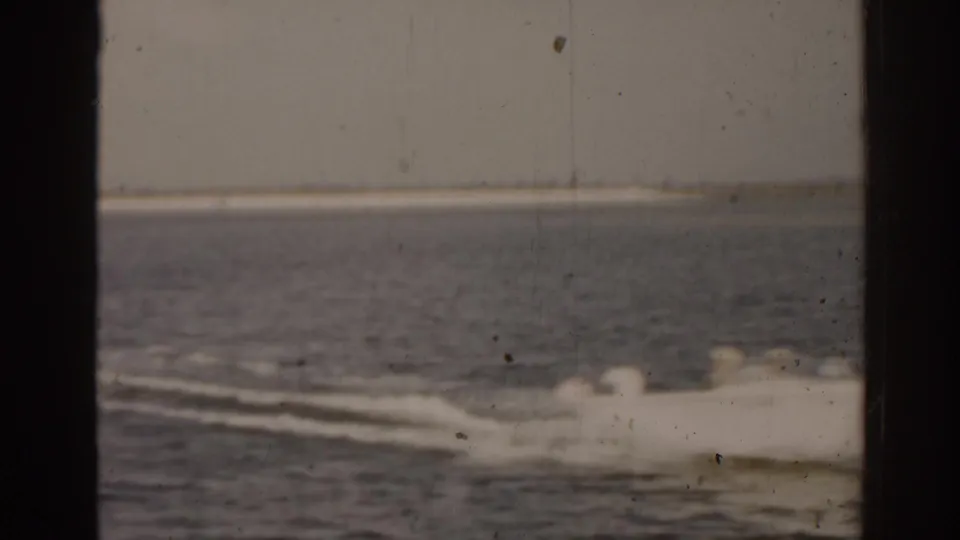 A motorboat appears to pass across a Florida waterway, softened by 8mm grain and fading color.