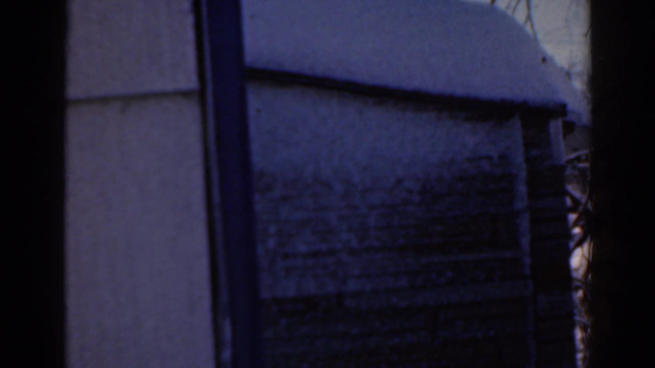 Blue-tinted wall and snowy ground framed by dark vertical edges.