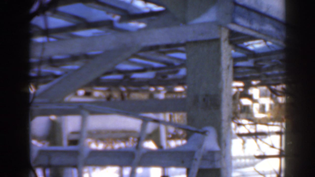 Snow-covered metal beams and posts seen through a dark 8mm frame edge.