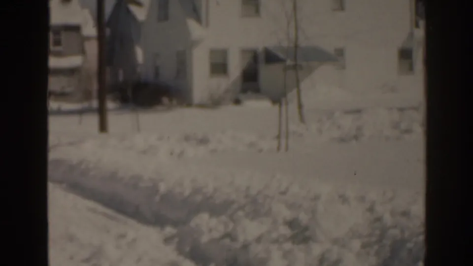 1963 Florida home-movie view of a white residential house and deep snow along the lawn and roadside.