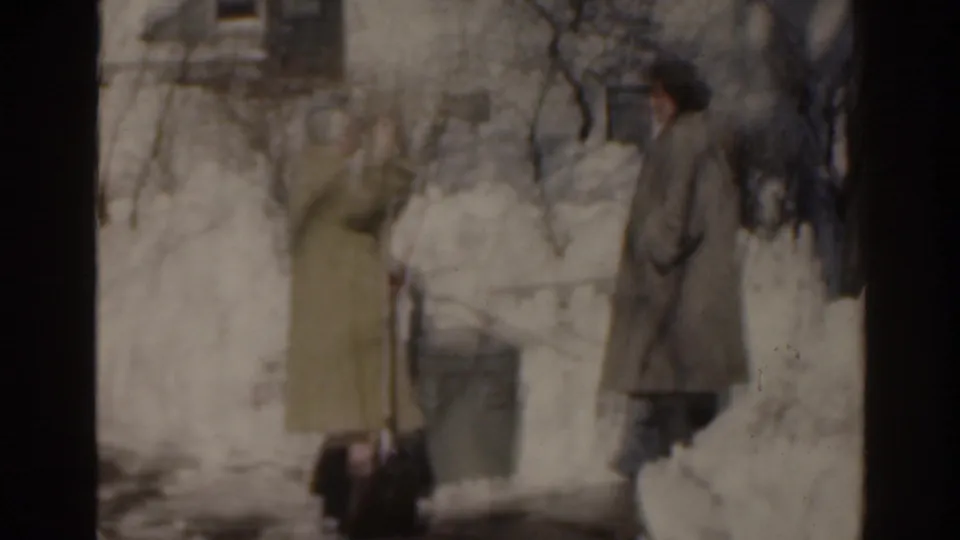 Two women converse outside a snow-covered house in the 1963 Florida home-movie footage.
