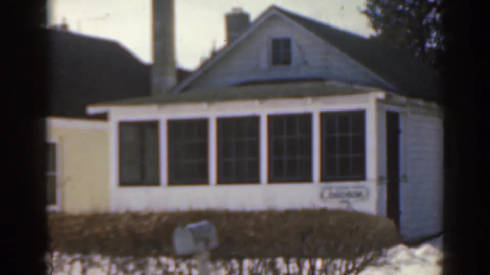 1963 Florida frame showing the front of a white house, broad bay window, snow in the yard, and an E. Dodson nameplate.