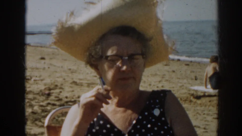 In the final frame, the woman holds a cigarette near her face beneath a straw hat, with the shoreline and beachgoer in the background.