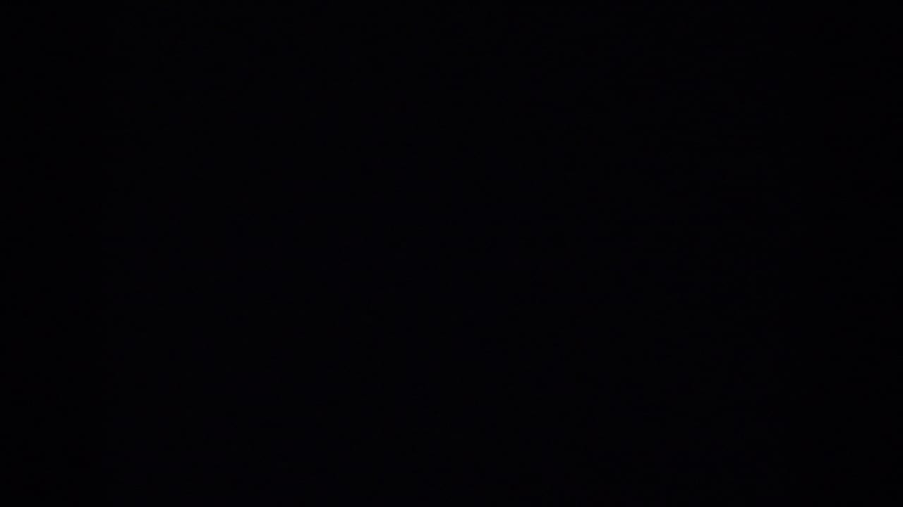 Partial 1963 New Jersey home-movie frame showing a suburban house and yard through a dark obstruction.