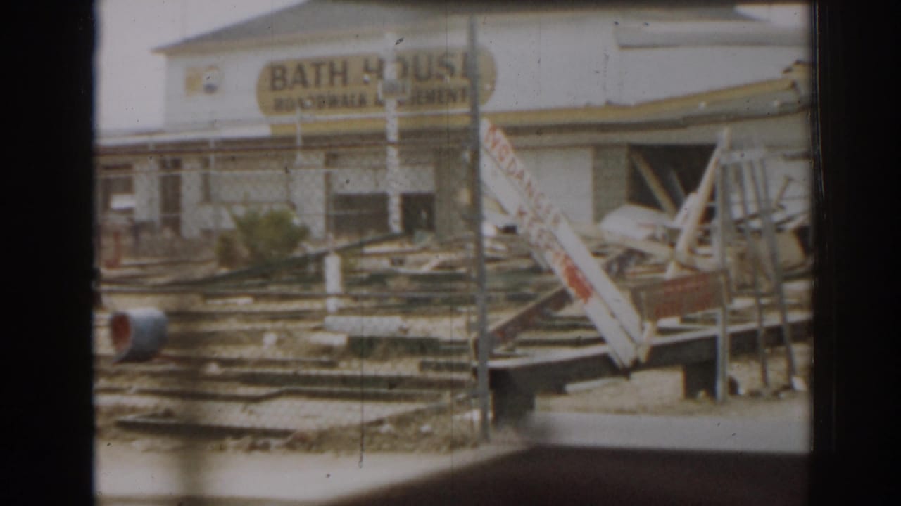 Damaged bath house frontage with debris and broken structures in front.