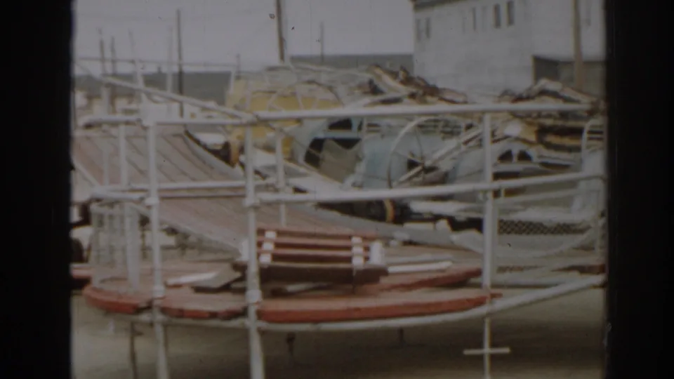 1963 New Jersey 8mm frame showing a wrecked playground with bent metal rails, platforms, and broken equipment.