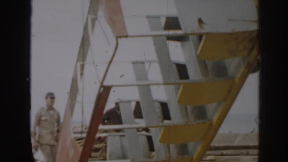 The large metal structure fills most of the 8mm frame, with two men visible near construction materials in New Jersey.