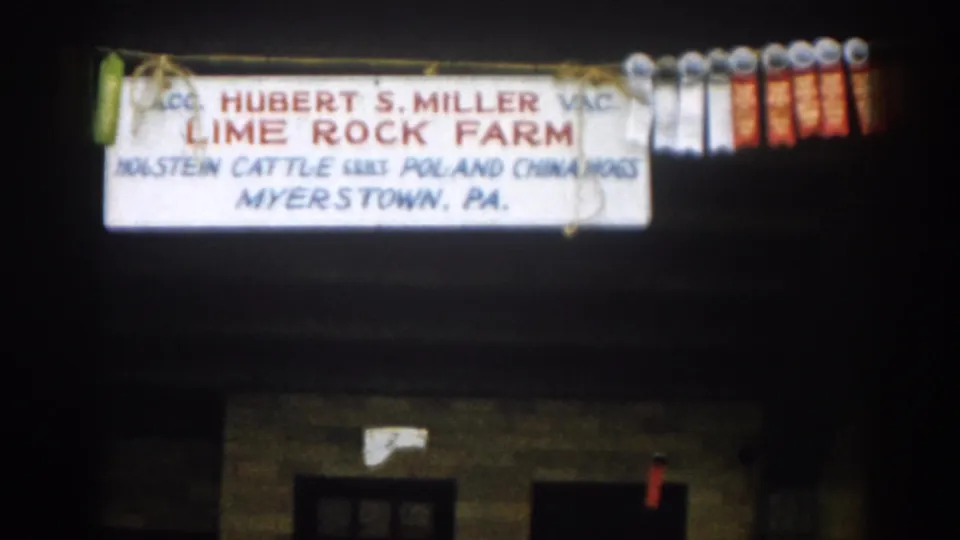 A closer 8mm view of the Lime Rock Farm sign shows Hubert S. Miller, livestock descriptions, Myerstown, PA, and prize ribbons.