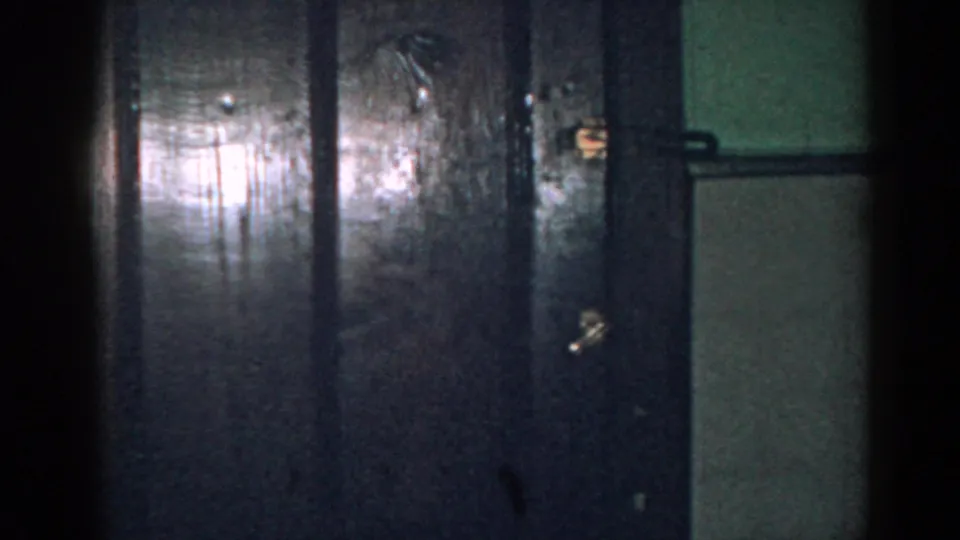 Dim 1963 New Jersey house interior with dark doors, wall panels, and visible 8mm grain.