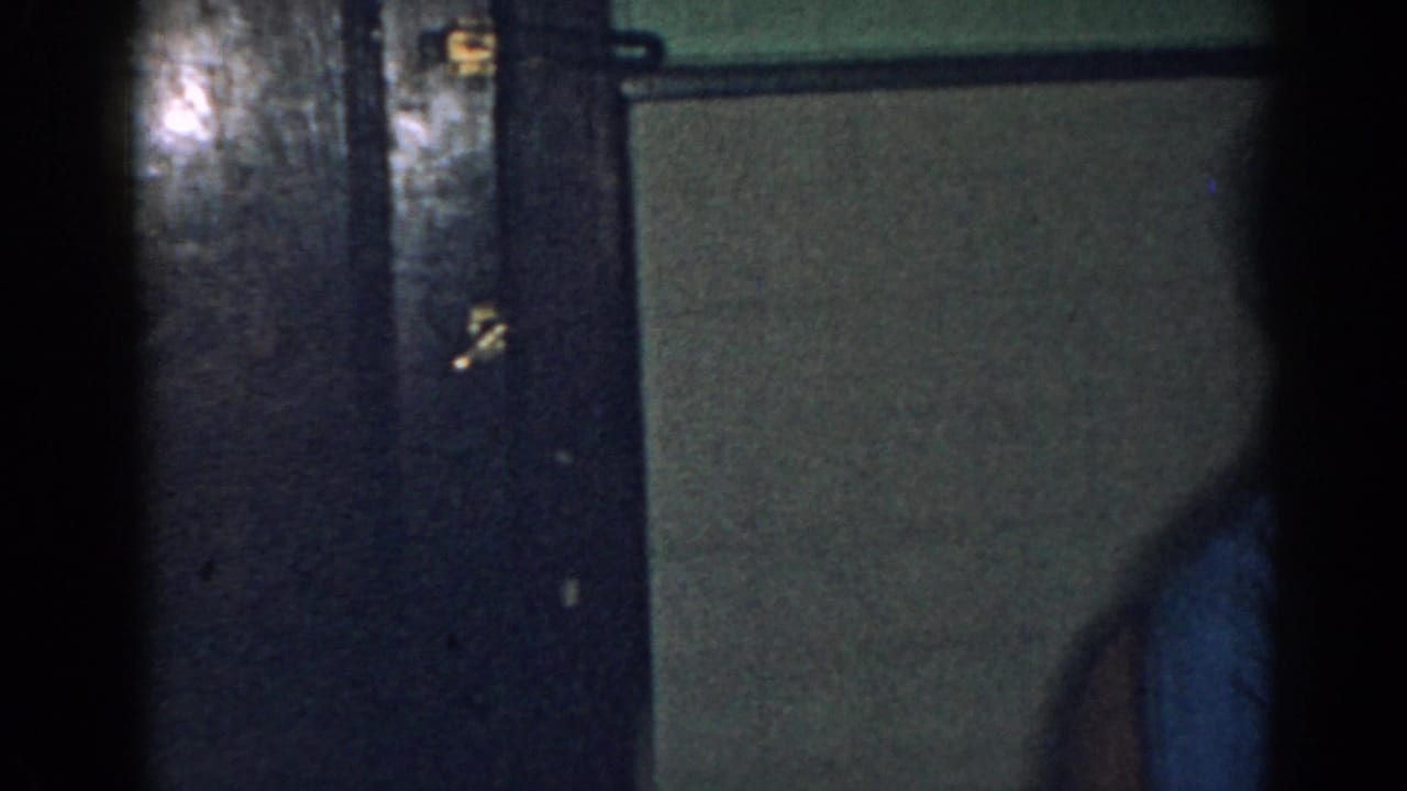 Dim New Jersey home interior with dark doors and a partial adult figure at the frame edge.