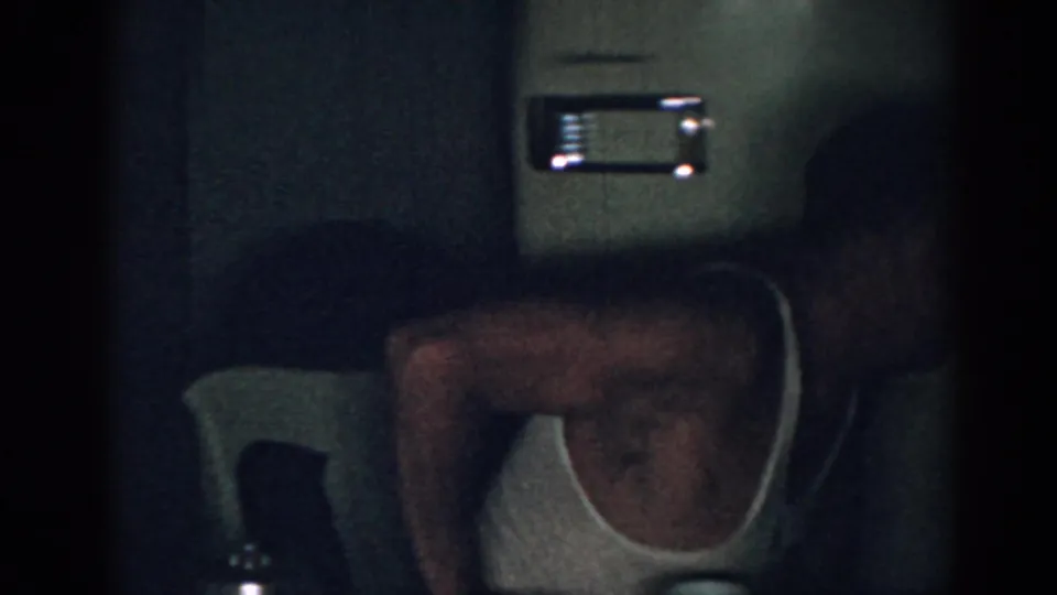 The final frame shows the man turned partly away in the dim room, with the wall-mounted unit still visible on the interior wall.