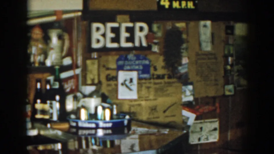 1963 New Jersey bar interior showing a prominent BEER sign, drink trays, bottles, mugs, posters, and rustic wall details.