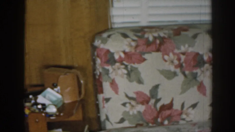 1963 New Jersey home interior showing a closer view of floral furniture against wood paneling with a small table at left.
