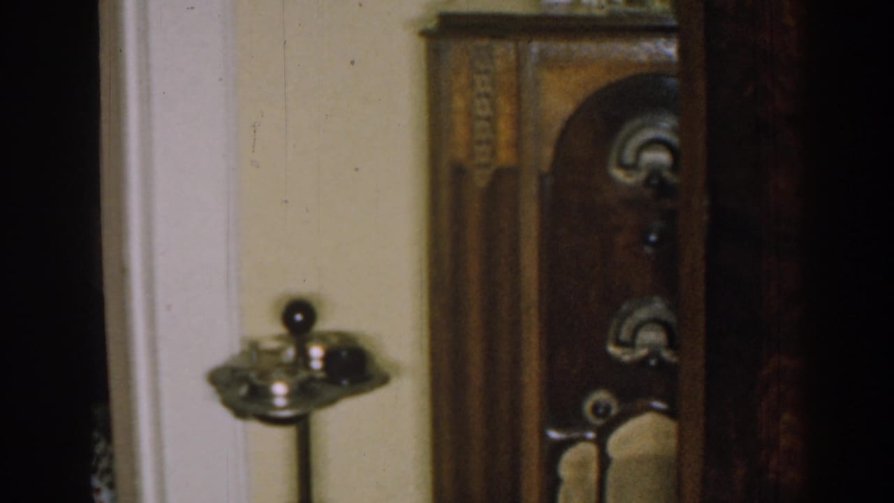 Closer view of the carved wooden cabinet with an arched door and small objects on top.