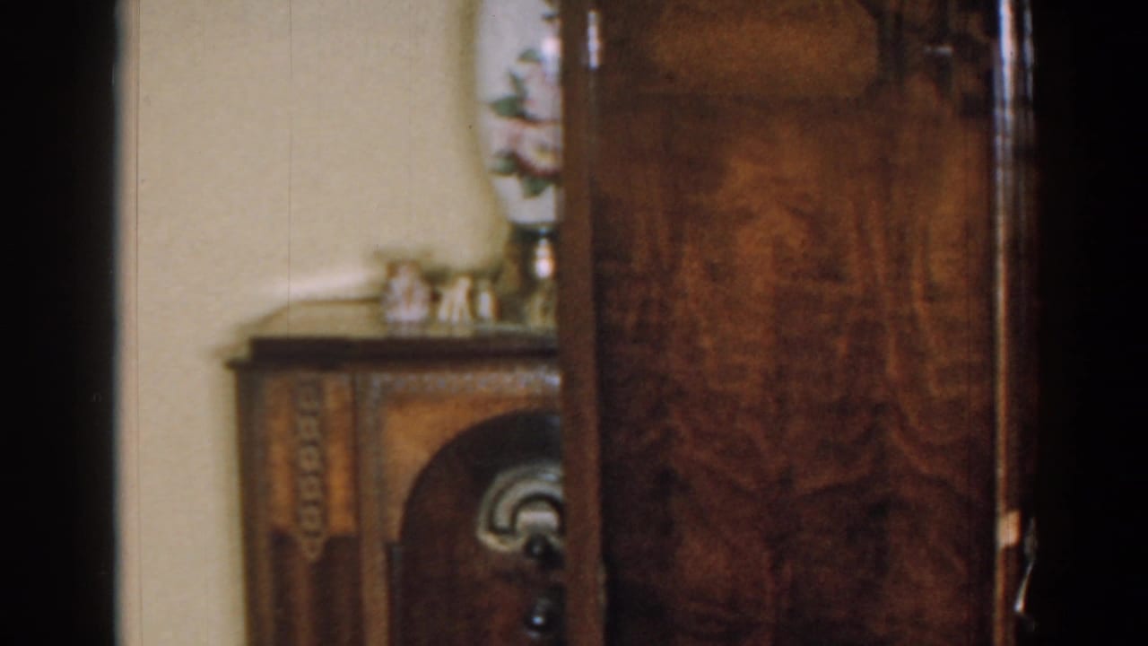 Wooden cabinet beside a smaller decorative furniture piece with vase and figurines.
