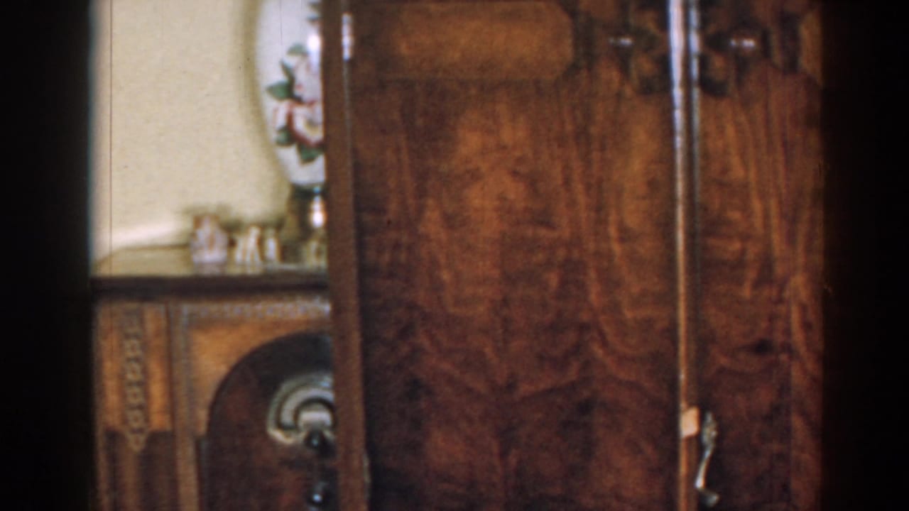 Large wood-grain cabinet in a 1963 New Jersey private interior, with a small decorated furniture piece partly visible.