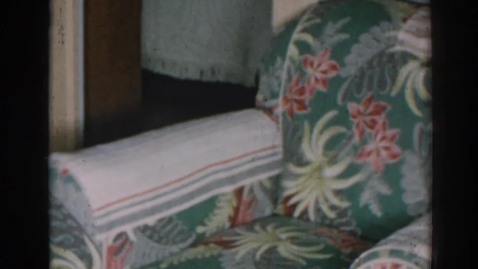 1963 New Jersey home interior showing the patterned back cushion and striped arm cover of a tropical floral upholstered chair.