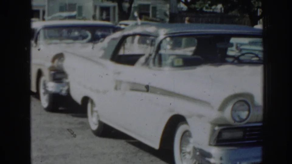 1963 New Jersey frame showing a white mid-century sedan parked on a street, with soft 8mm color and visible wear.
