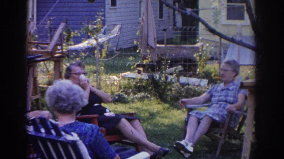 The 1963 New Jersey backyard footage shows three older adults seated, including one woman holding a tissue near her face.
