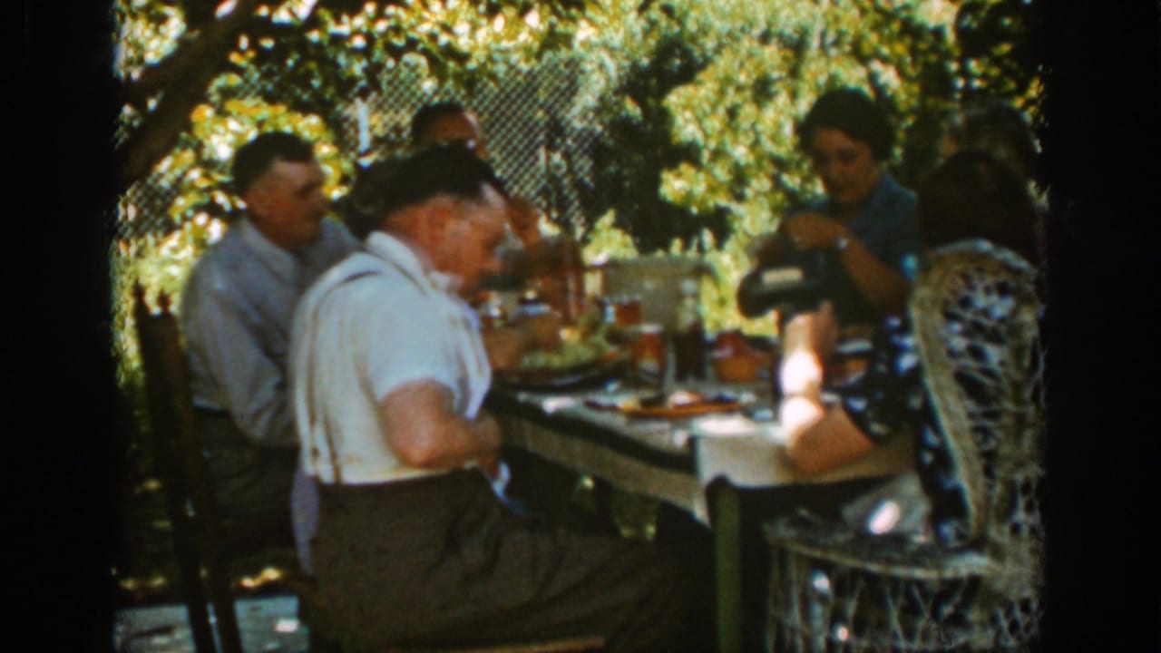 Adults at a picnic table with one person pouring or handling a drink.