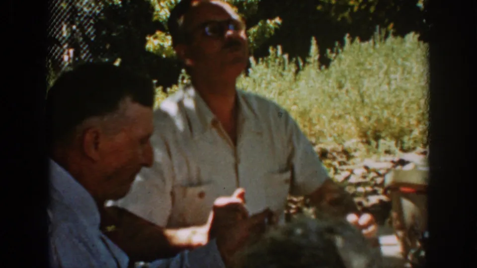 Auburn, California 1939 frame showing a man in sunglasses seated at a picnic table with another guest in the foreground.