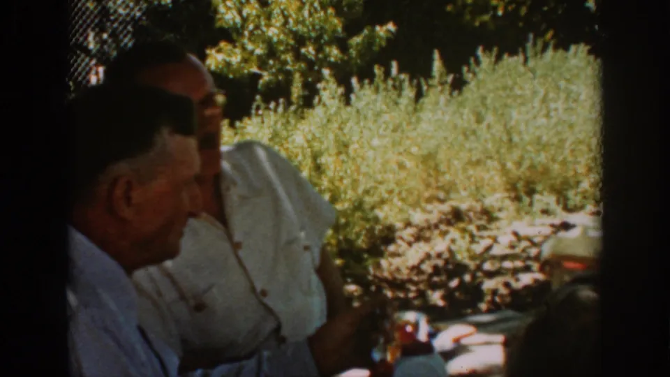 In the 1939 Auburn scene, the men remain seated in shade while the speaker turns during the conversation.