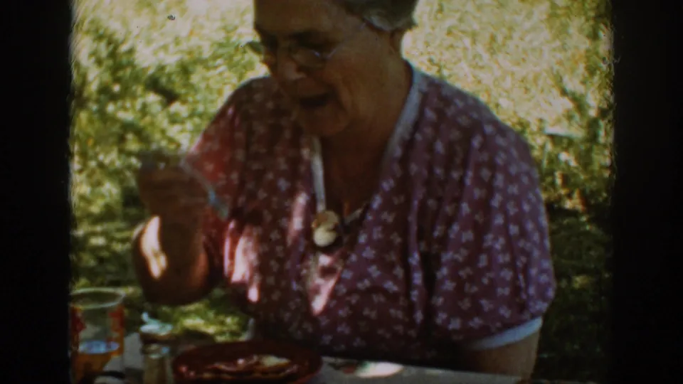 Auburn, California 1939 home-movie frame showing a seated adult in glasses at an outdoor table during the meal.